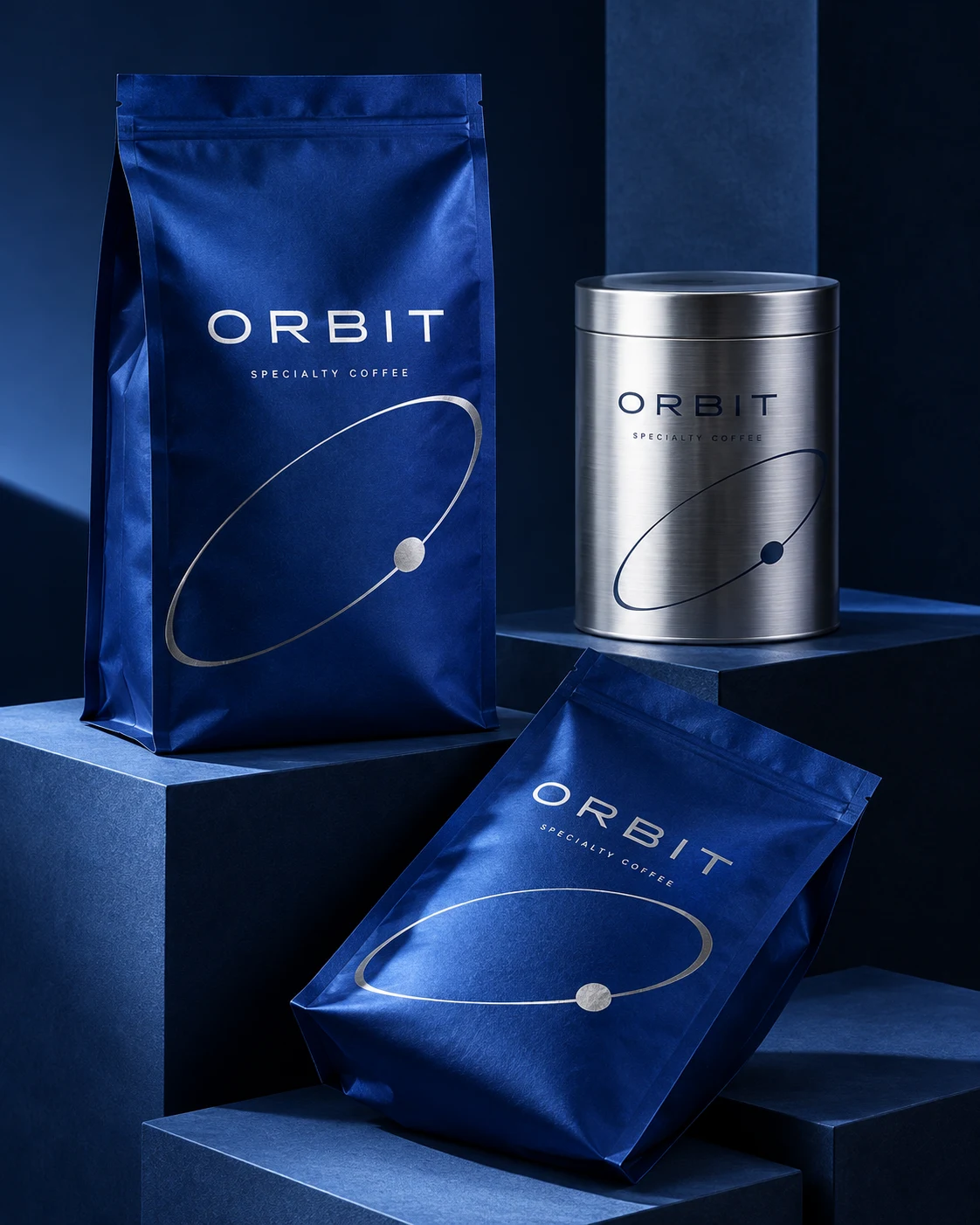 Orbit specialty coffee packaging concept with cobalt blue bags and a brushed silver tin on navy display plinths.